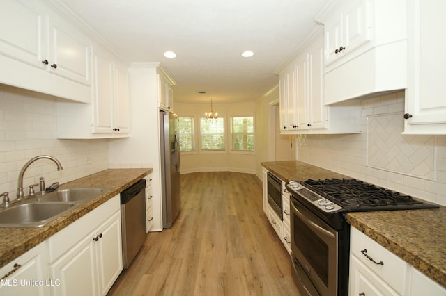 kitchen with stainless steel appliances, a notable chandelier, light wood-type flooring, white cabinets, and sink