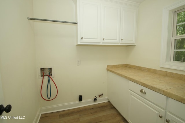 laundry area with gas dryer hookup, washer hookup, cabinets, and dark wood-type flooring