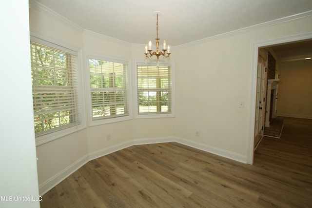 unfurnished dining area with ornamental molding, a notable chandelier, and dark hardwood / wood-style floors