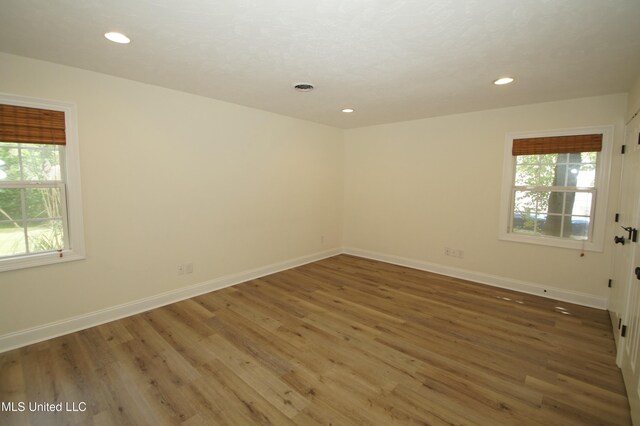 spare room featuring plenty of natural light and dark hardwood / wood-style floors