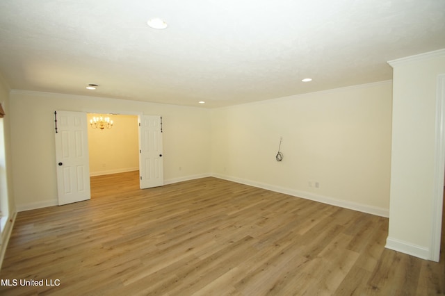 unfurnished room with ornamental molding, light hardwood / wood-style flooring, and a chandelier