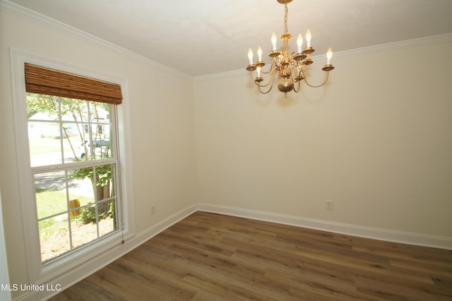 empty room with dark hardwood / wood-style flooring, an inviting chandelier, a healthy amount of sunlight, and crown molding