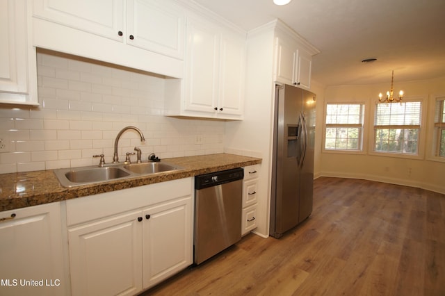 kitchen featuring appliances with stainless steel finishes, dark hardwood / wood-style flooring, sink, white cabinetry, and an inviting chandelier