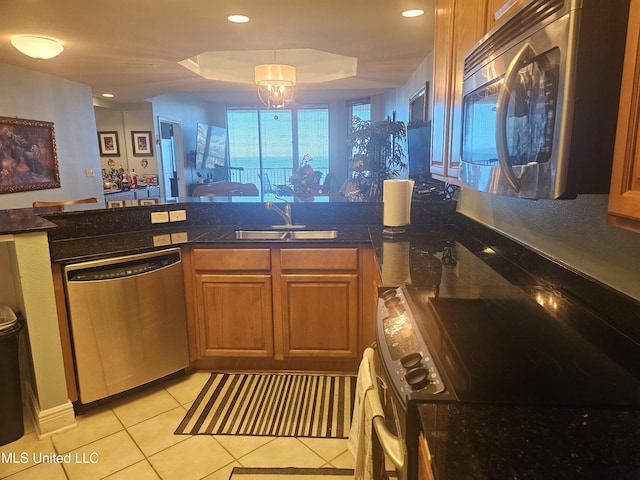 2668 Beach Blvd Unit 702, Biloxi, MS 39531 - kitchen featuring stainless steel appliances, a sink, brown cabinetry, light tile patterned flooring, and a peninsula