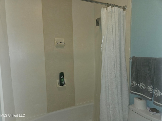 bathroom featuring shower / bath combination with curtain and toilet