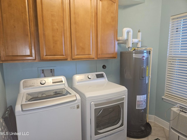 clothes washing area featuring washer and clothes dryer, tile patterned flooring, cabinets, and water heater