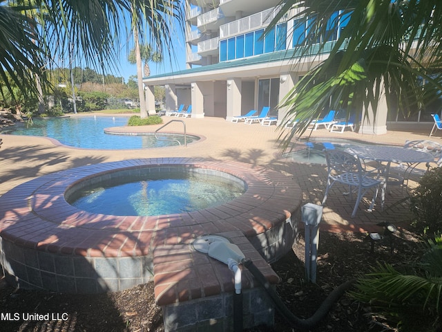 view of pool featuring a patio area and a hot tub