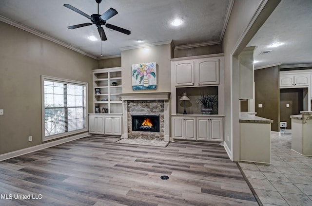 127 Rockbridge Cir, Clinton, MS 39056 - unfurnished living room with ceiling fan, a stone fireplace, ornamental molding, light wood-style flooring, and recessed lighting