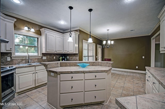 127 Rockbridge Cir, Clinton, MS 39056 - kitchen featuring tile countertops, a center island, stainless steel range with electric stovetop, tasteful backsplash, and ornamental molding