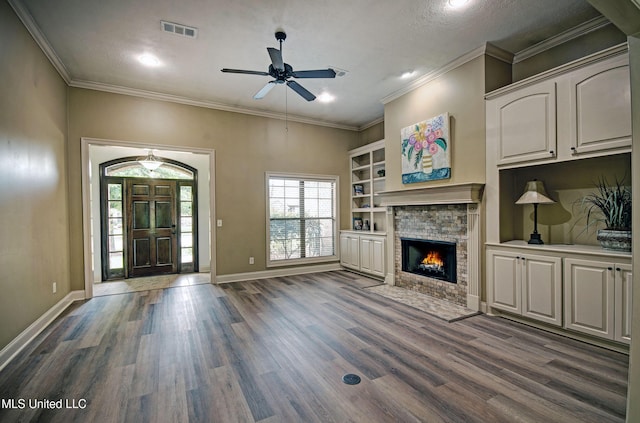 127 Rockbridge Cir, Clinton, MS 39056 - unfurnished living room featuring dark wood finished floors, a stone fireplace, a ceiling fan, ornamental molding, and recessed lighting