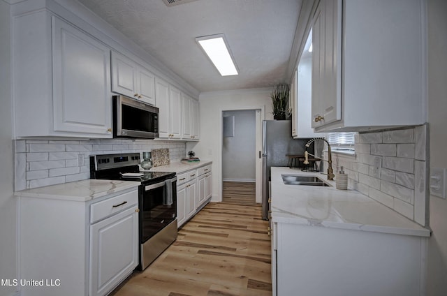226 N Shenandoah Rd, Brandon, MS 39047 - kitchen with stainless steel appliances, white cabinetry, light wood-type flooring, decorative backsplash, and light stone counters