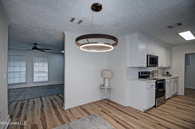 226 N Shenandoah Rd, Brandon, MS 39047 - kitchen featuring stainless steel appliances, light wood-style flooring, light countertops, a textured ceiling, and decorative backsplash