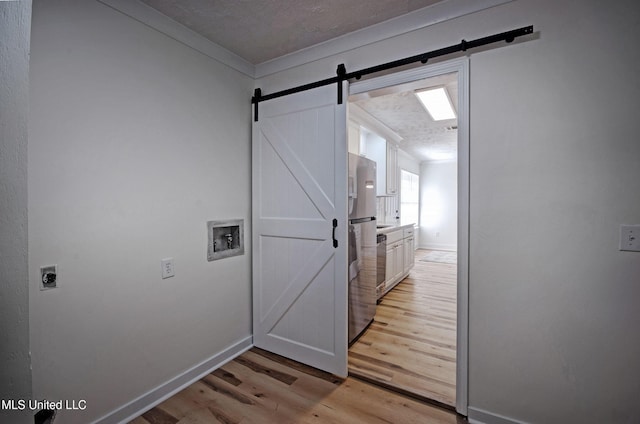 226 N Shenandoah Rd, Brandon, MS 39047 - laundry room featuring a barn door, hookup for an electric dryer, washer hookup, light wood-style flooring, and crown molding