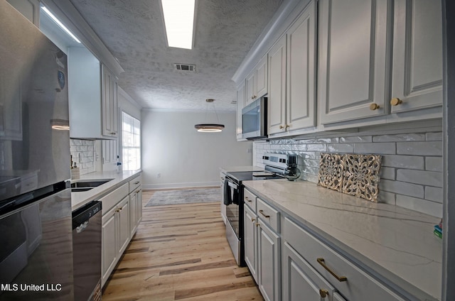 226 N Shenandoah Rd, Brandon, MS 39047 - kitchen featuring stainless steel appliances, a textured ceiling, light wood finished floors, tasteful backsplash, and light stone countertops