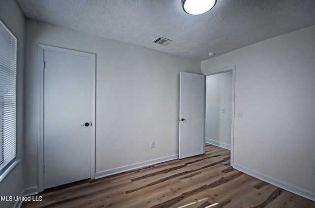 226 N Shenandoah Rd, Brandon, MS 39047 - unfurnished bedroom with wood finished floors and a textured ceiling