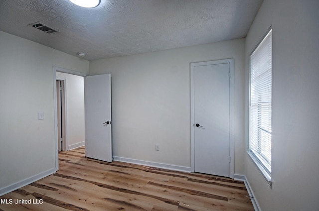 226 N Shenandoah Rd, Brandon, MS 39047 - unfurnished bedroom with light wood-type flooring and a textured ceiling
