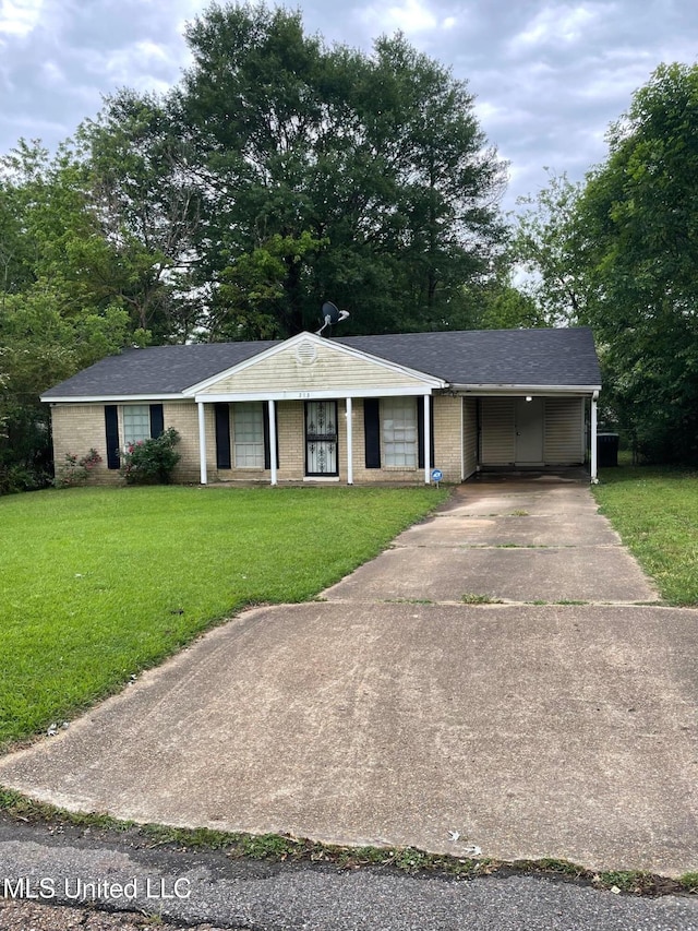 single story home featuring concrete driveway, a front lawn, an attached carport, and brick siding