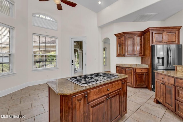 17000 River Pl, Vancleave, MS 39565 - kitchen with appliances with stainless steel finishes, arched walkways, a ceiling fan, light tile patterned floors, and high vaulted ceiling