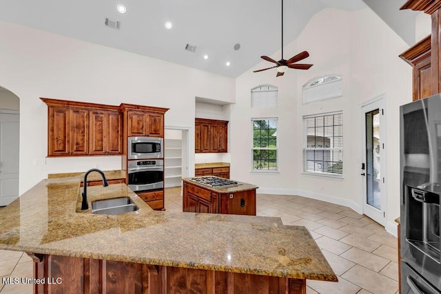 17000 River Pl, Vancleave, MS 39565 - kitchen with appliances with stainless steel finishes, a sink, a ceiling fan, light tile patterned floors, and a center island