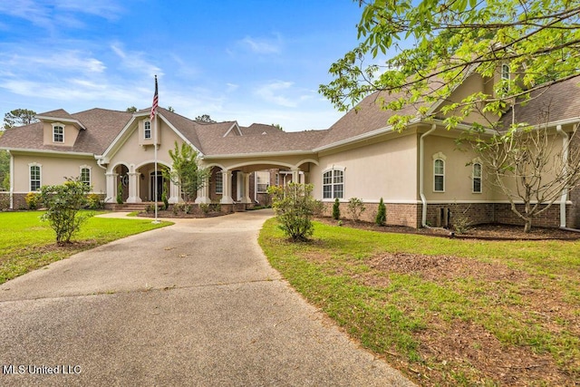 17000 River Pl, Vancleave, MS 39565 - view of front facade featuring stucco siding, a front lawn, and curved driveway
