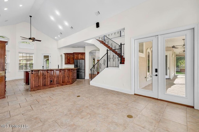 17000 River Pl, Vancleave, MS 39565 - unfurnished living room featuring ceiling fan, stairs, arched walkways, healthy amount of natural light, and high vaulted ceiling