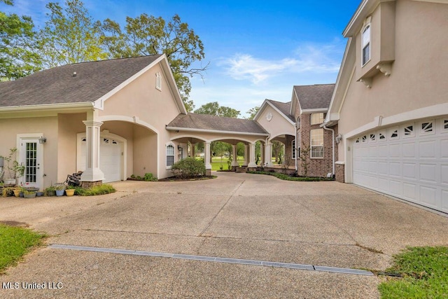 17000 River Pl, Vancleave, MS 39565 - view of front facade featuring driveway, stucco siding, a garage, and roof with shingles