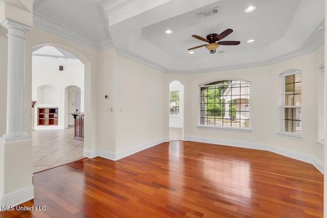17000 River Pl, Vancleave, MS 39565 - empty room featuring hardwood / wood-style floors, a raised ceiling, a ceiling fan, arched walkways, and crown molding
