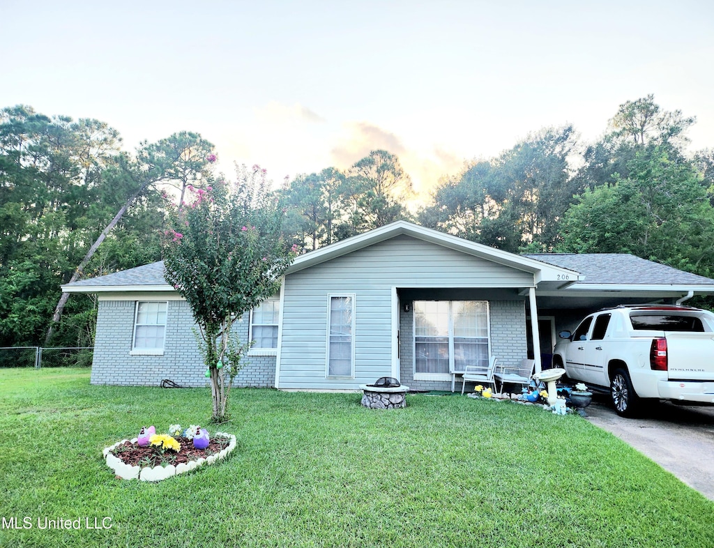 ranch-style home with a yard and a carport