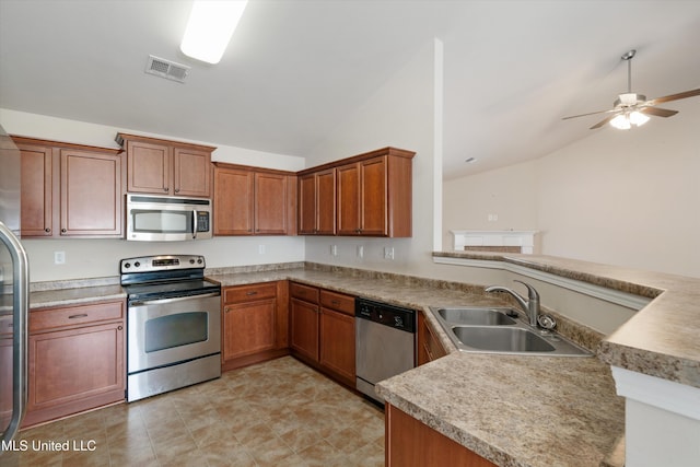 kitchen with lofted ceiling, stainless steel appliances, kitchen peninsula, and sink