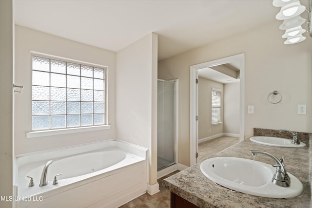 bathroom featuring vanity, shower with separate bathtub, and a healthy amount of sunlight