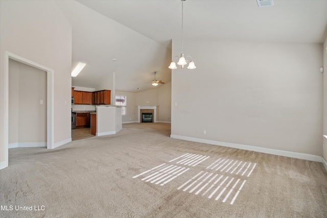 unfurnished living room featuring ceiling fan with notable chandelier, light carpet, and high vaulted ceiling