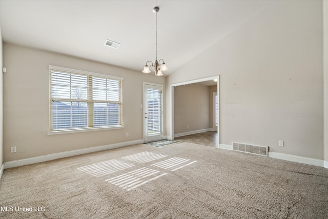 spare room with an inviting chandelier, light colored carpet, and high vaulted ceiling