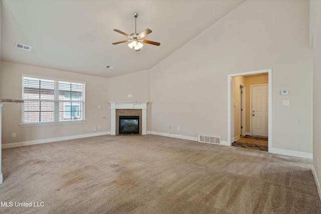 unfurnished living room with a tiled fireplace, ceiling fan, light carpet, and high vaulted ceiling