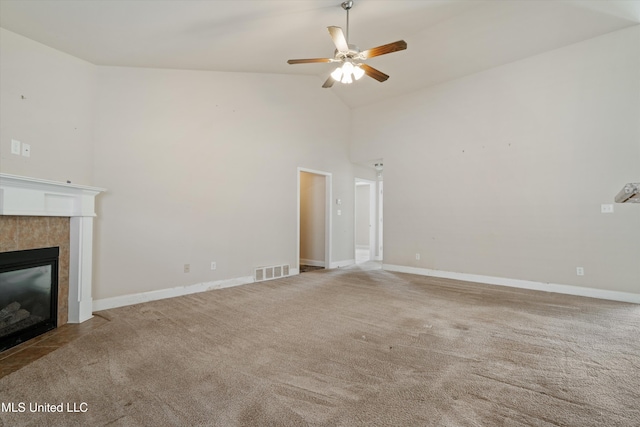 unfurnished living room featuring a tiled fireplace, high vaulted ceiling, light carpet, and ceiling fan