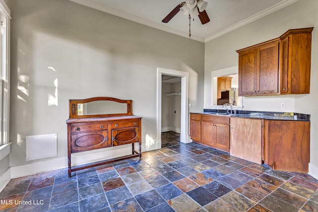 kitchen featuring crown molding, a towering ceiling, sink, and ceiling fan