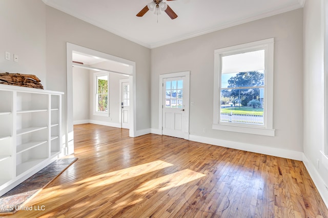 foyer entrance featuring ornamental molding, wood-type flooring, and ceiling fan