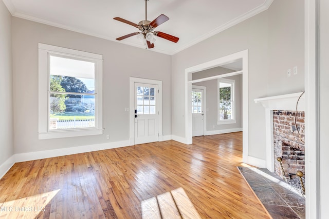 entrance foyer with crown molding, hardwood / wood-style floors, a fireplace, and ceiling fan