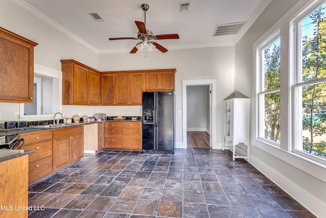 kitchen with sink, ceiling fan, crown molding, and black fridge