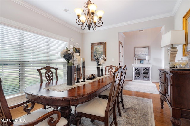 8063 Elizabeth Dr, Olive Branch, MS 38654 - dining room featuring a chandelier, light wood-type flooring, crown molding, and baseboards