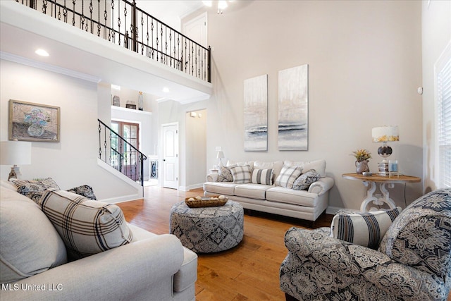 8063 Elizabeth Dr, Olive Branch, MS 38654 - living area featuring stairway, a towering ceiling, wood finished floors, and baseboards
