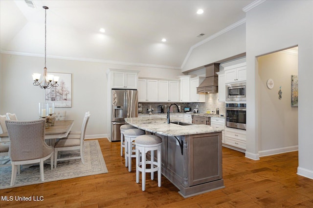 8063 Elizabeth Dr, Olive Branch, MS 38654 - kitchen featuring stainless steel appliances, lofted ceiling, premium range hood, a sink, and tasteful backsplash
