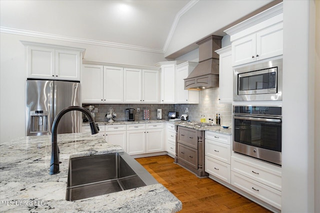 8063 Elizabeth Dr, Olive Branch, MS 38654 - kitchen featuring stainless steel appliances, ornamental molding, lofted ceiling, custom range hood, and white cabinets