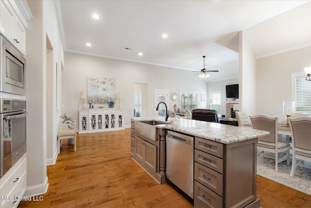 8063 Elizabeth Dr, Olive Branch, MS 38654 - kitchen featuring stainless steel appliances, a sink, ornamental molding, ceiling fan, and light wood-style floors