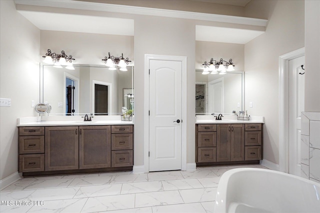 8063 Elizabeth Dr, Olive Branch, MS 38654 - full bathroom featuring marble finish flooring, a bath, baseboards, and two vanities