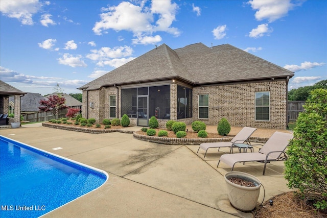 8063 Elizabeth Dr, Olive Branch, MS 38654 - rear view of property featuring brick siding, roof with shingles, a patio area, and a sunroom