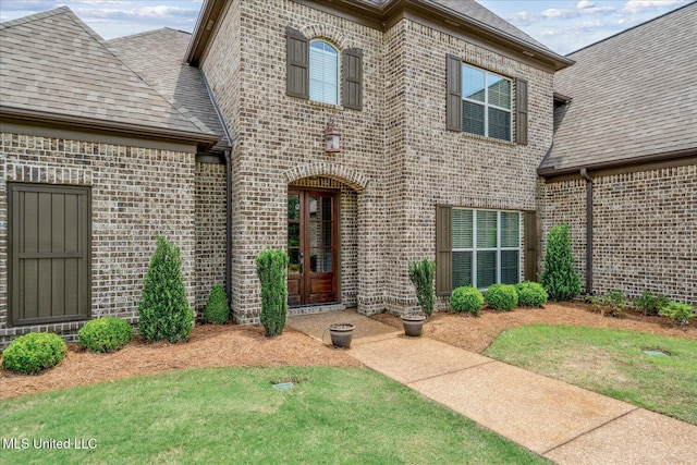 8063 Elizabeth Dr, Olive Branch, MS 38654 - doorway to property featuring brick siding, a yard, and a shingled roof