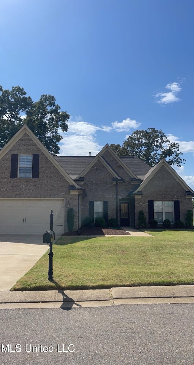 7497 Redberry Dr, Horn Lake, MS 38637 - view of front facade with a front yard, brick siding, and concrete driveway