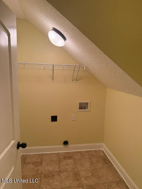 7497 Redberry Dr, Horn Lake, MS 38637 - laundry room featuring hookup for a washing machine, electric dryer hookup, baseboards, tile patterned floors, and a textured ceiling