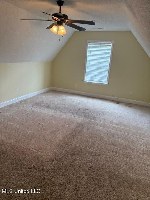 7497 Redberry Dr, Horn Lake, MS 38637 - bonus room with vaulted ceiling, a ceiling fan, carpet flooring, a textured ceiling, and baseboards