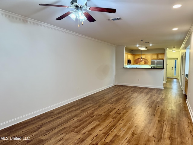 unfurnished living room with dark wood finished floors, visible vents, baseboards, and ornamental molding